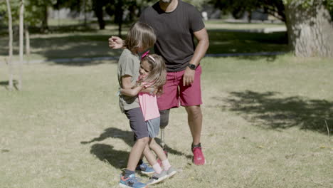 father with disability dancing with kids in summer park