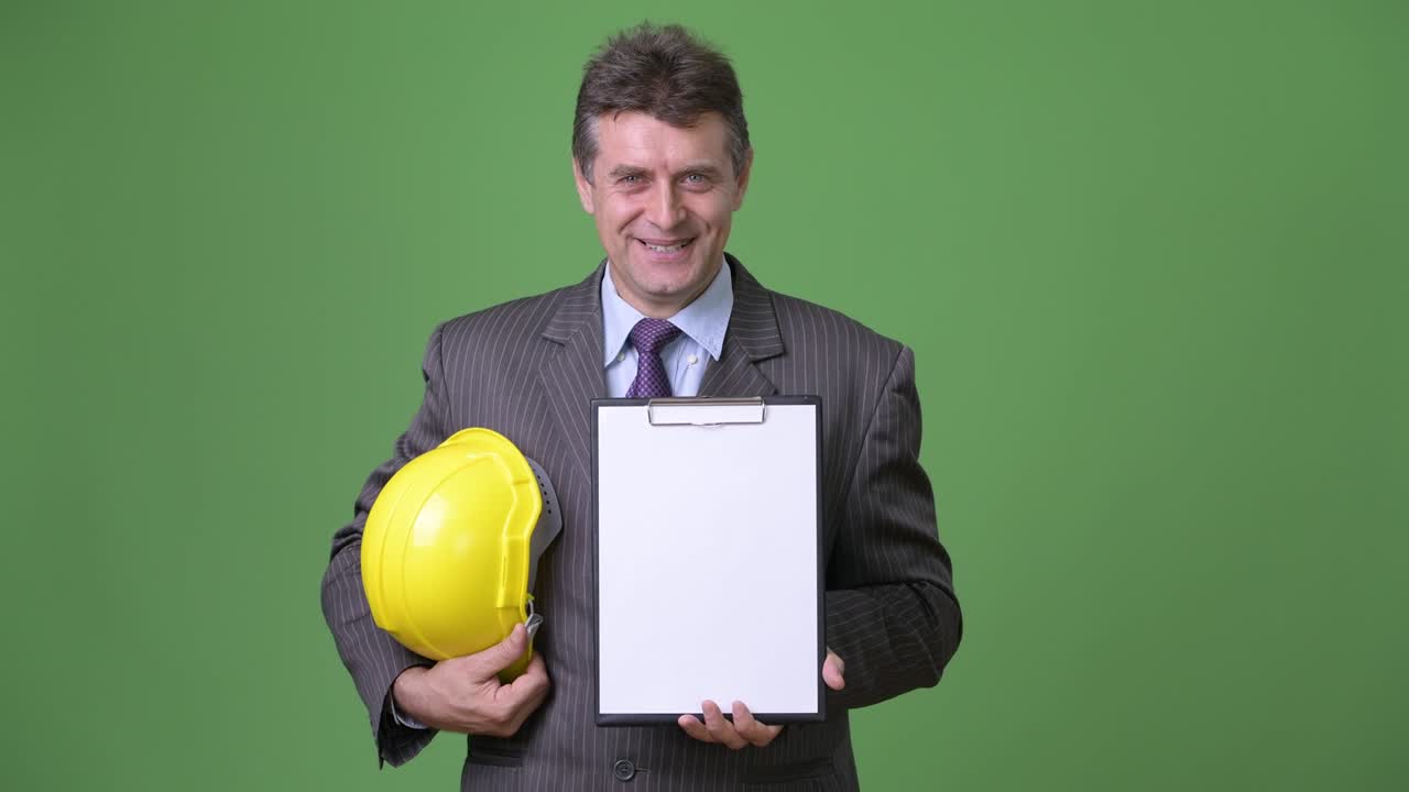 hombre de negocios maduro y guapo contra un fondo verde