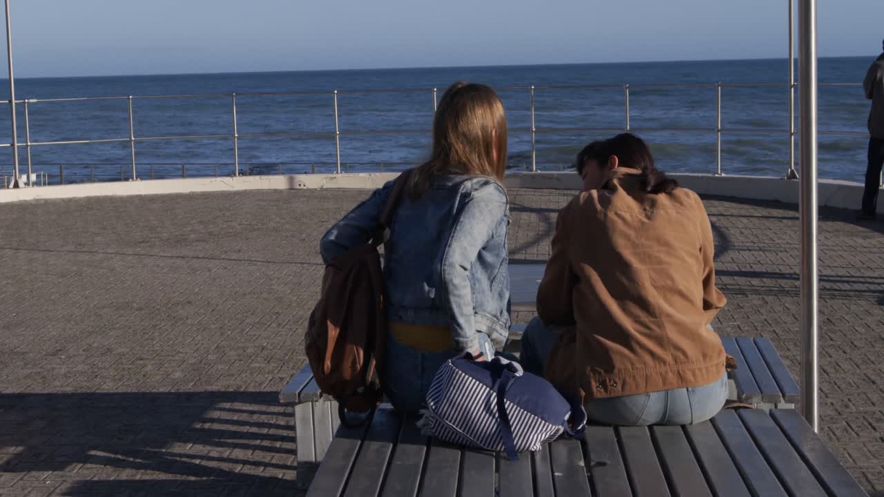 테이블 에 앉아 이야기 하는 백인 과 혼합 인종 소녀 의 뒷면