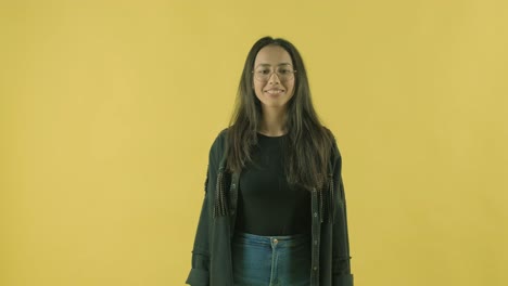 young beautiful girl with shopping bags on the yellow backgroun