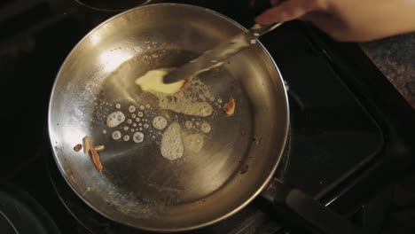 Canada---Melting-Butter-In-A-Hot-Stainless-Pan-Using-A-Dessert-Knife---Closeup-Shot