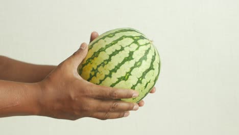 a man holding a ripe watermelon