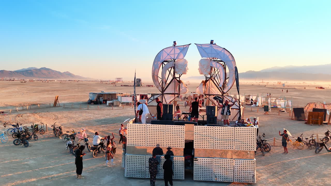 Nevada, USA, 14 August 2025: Stage performance and art installation at Burning Man festival in Nevada desert.. Artists perform on stage near a large sculpture at Burning Man