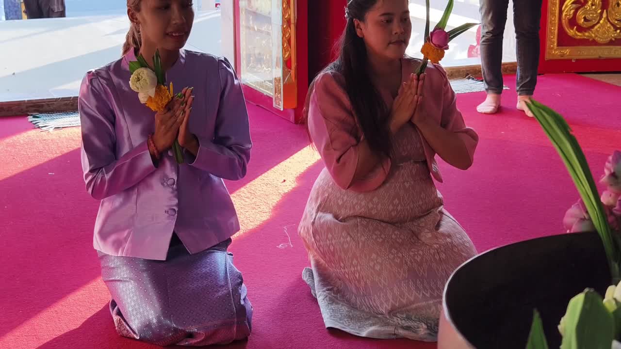 Frauen beten in einem thailändischen Tempel