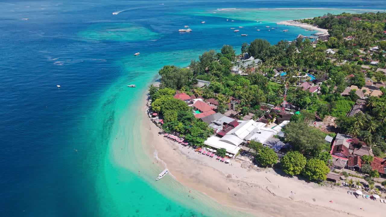 Orbita aerea che mostra la costa di un'isola tropicale con alberi lussureggianti, resort e oceano cristallino