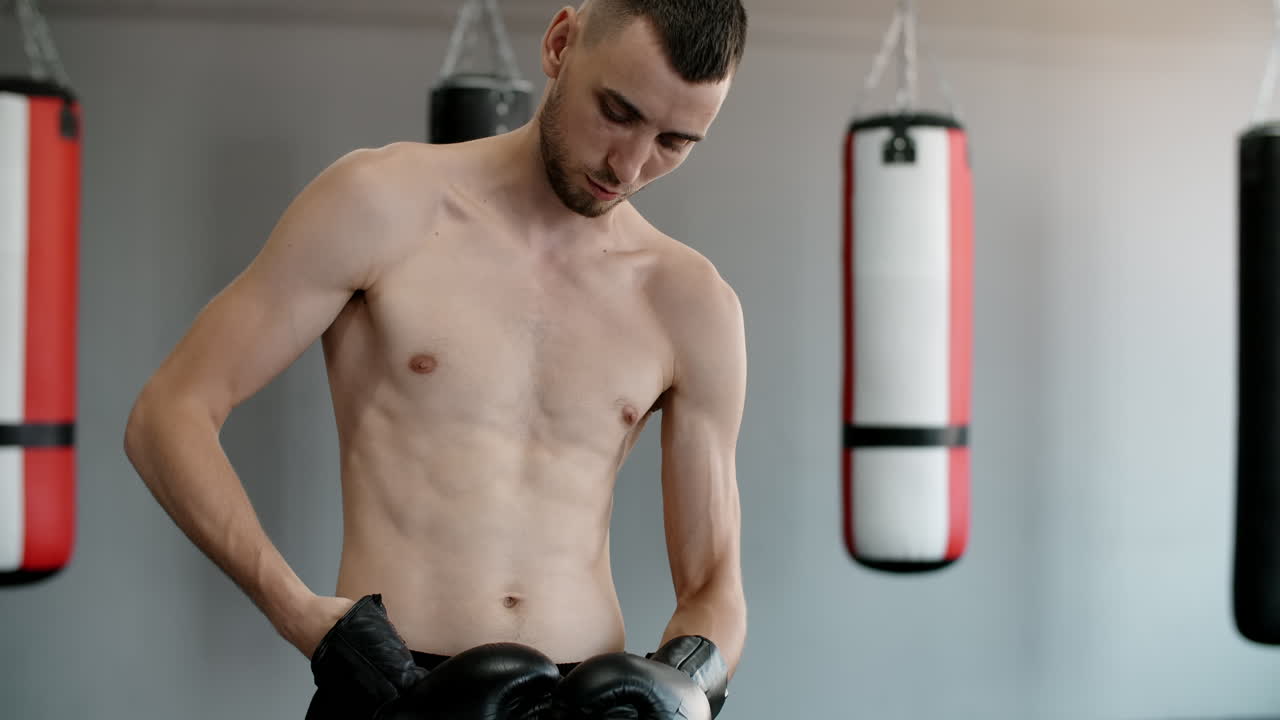 Man Putting on Boxing Gloves in Gym