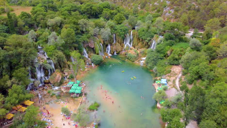 vista aérea de personas nadando en el agua prístina del río proveniente de la cascada de kravica