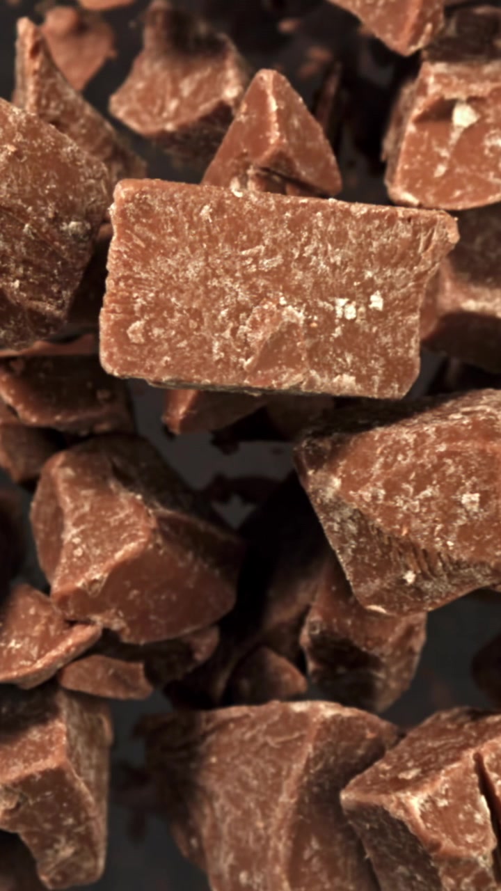 Ripresa macro di pezzi di cioccolato che cadono e si mettono a fuoco