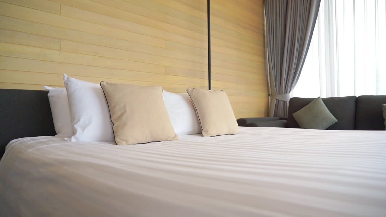 Elegant cozy king size bed in a hotel room, panning shot