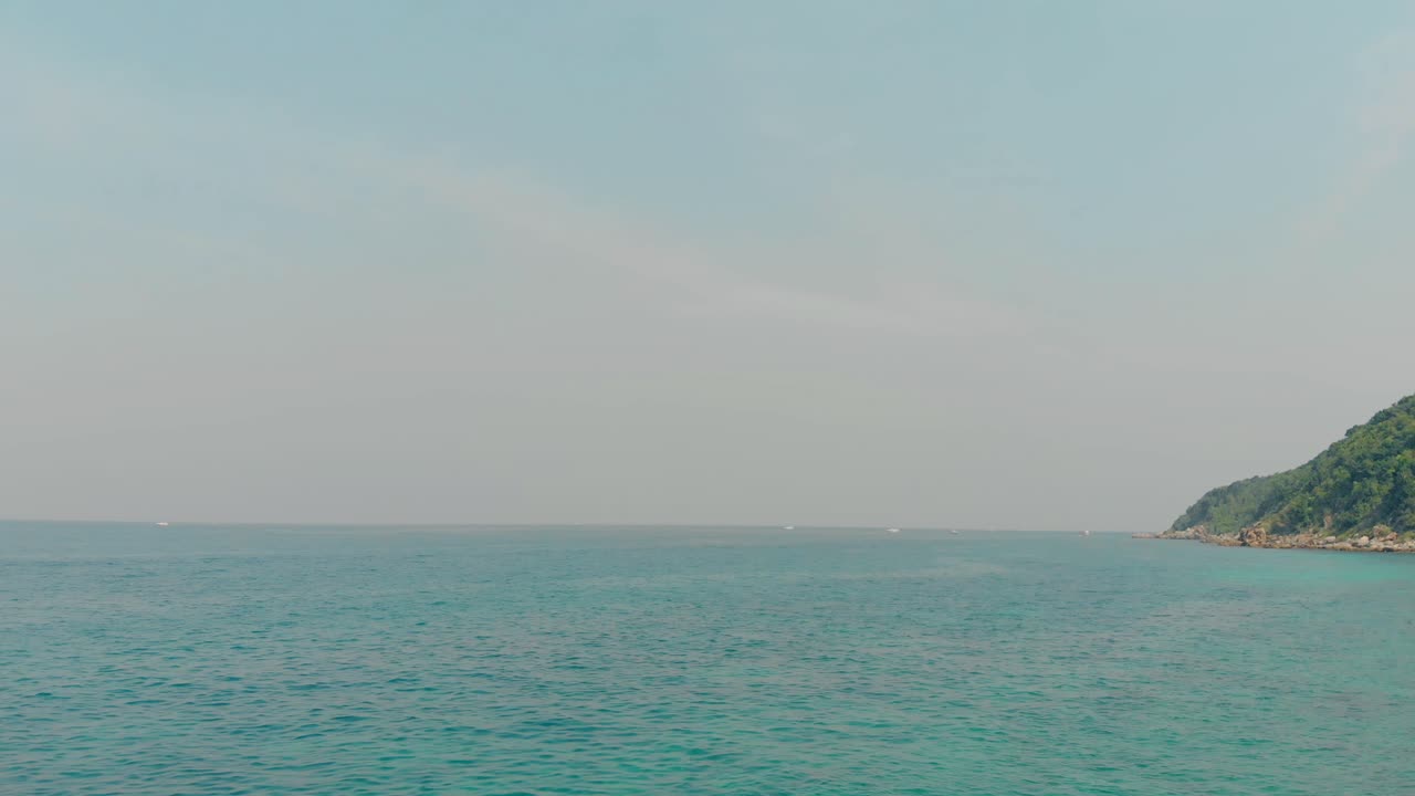 카메라는  ⁇ 은 파란 하늘, 바다, 언덕과 함께 멋진 전망을 촬영합니다.