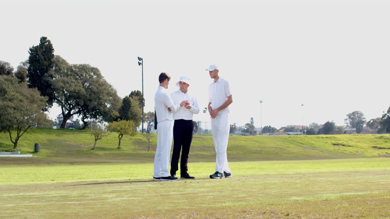 Cricket players discussing strategy on field during daytime practice session
