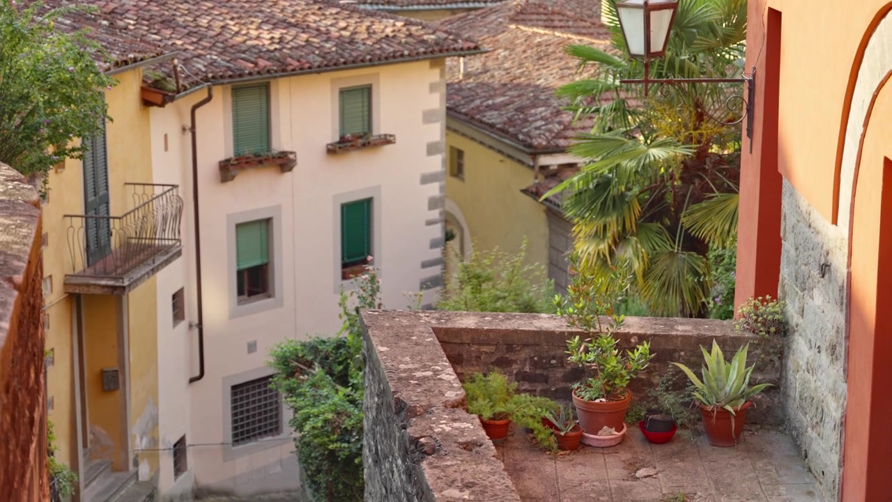 Bela e pitoresca cidade ou vila italiana pequena e característica no verão. Pequenos edifícios e casas medievais coloridos durante férias ou feriado em uma vila tranquila. Varandas de rua tranquilas