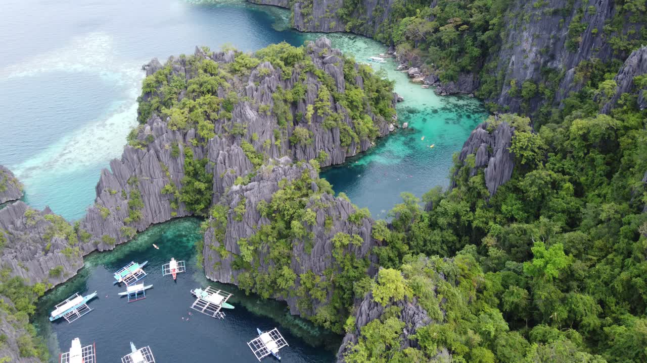 Acqua cristallina della laguna gemella tra imponenti formazioni carsiche e una lussureggiante vegetazione tropicale, Coron