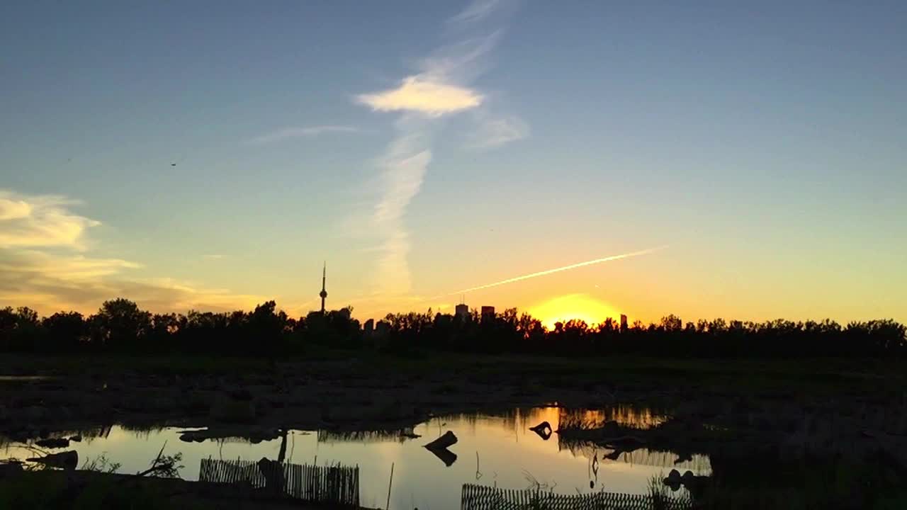 Sunset over the city skyline reflected in the lake