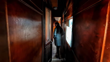 A-Woman-Is-Looking-Inside-The-Old-Fashioned-Train-Compartment