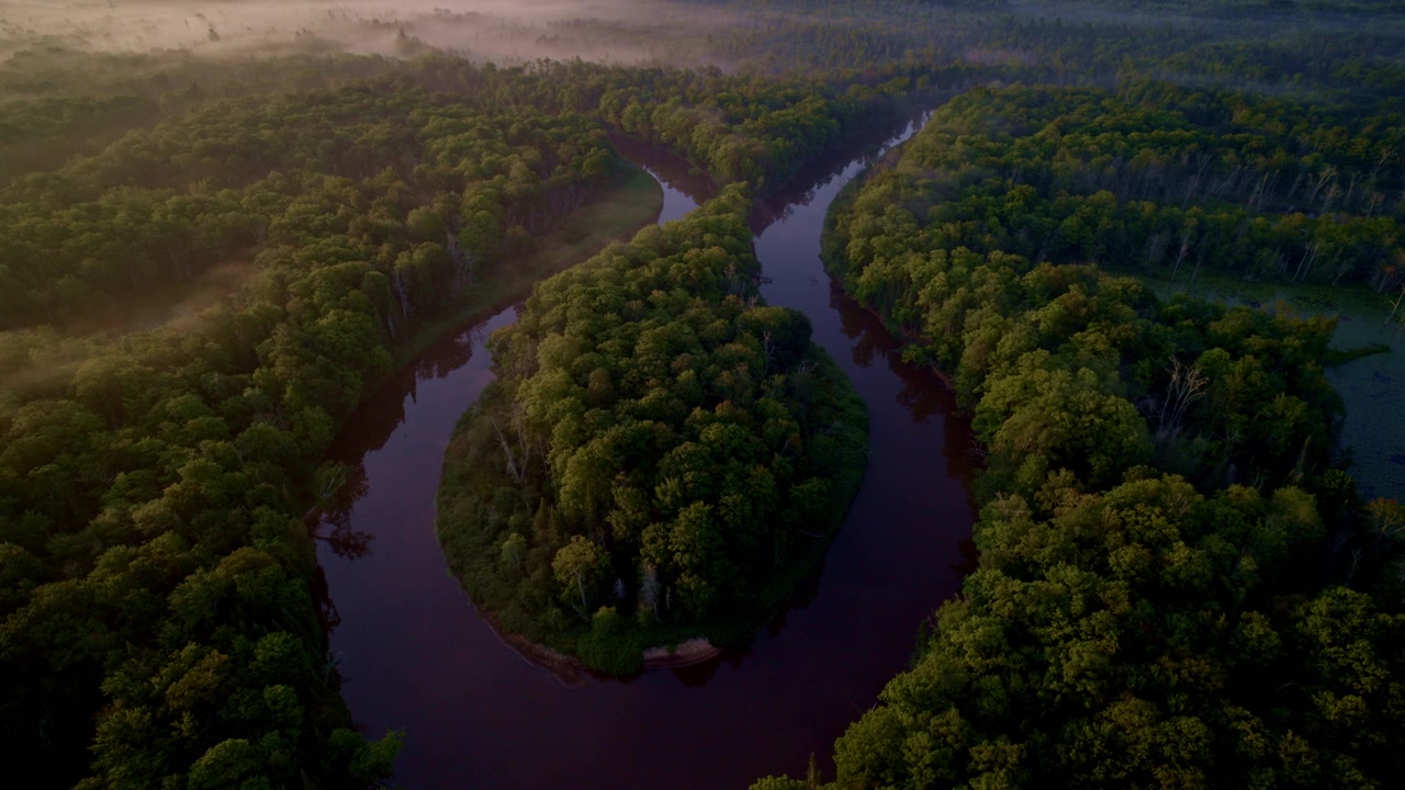 Tomada de drone panorâmica sobre a grande curva em forma de ferradura do rio Manistee na península superior de Michigan em uma manhã nebulosa de verão.