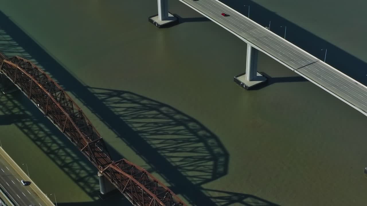 Cars travel across a long bridge over water in California