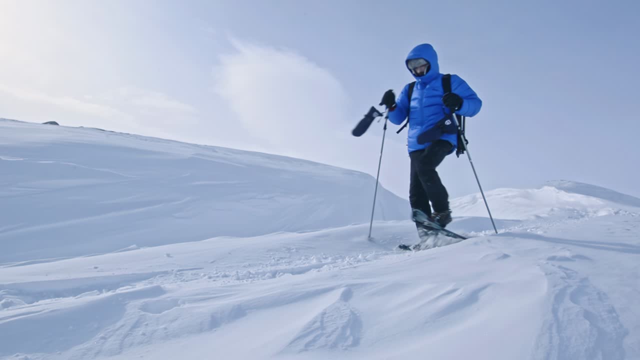 un turista en raquetas de nieve desciende de las montañas cubertas de nieve