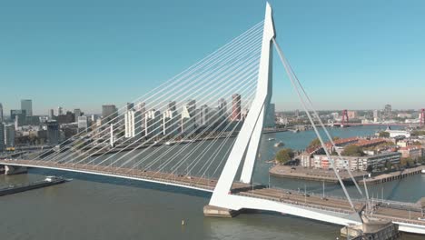 aerial drone footage of the erasmus bridge, the swan, crossing over the few water channels of rotterdam, netherlands