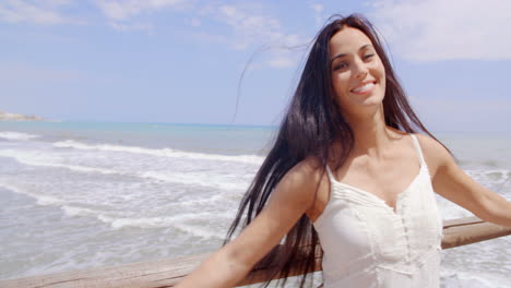 Mujer-Feliz-En-La-Barandilla-Con-El-Pelo-Soplado-Por-Aire