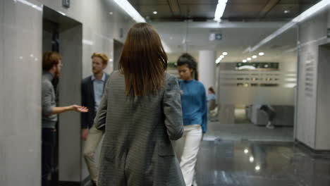 Business-woman-exiting-elevator-in-office.-Female-executive-walking-in-lobby