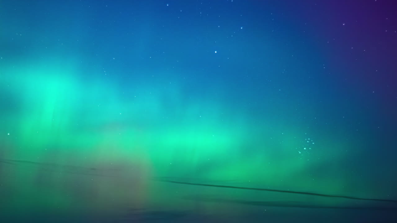 Timelapse di un'aurora boreale colorata con luci verdi e viola che si muovono nel cielo notturno stellato.