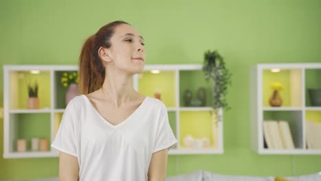 una joven feliz y pacífica que se siente alegre en casa.