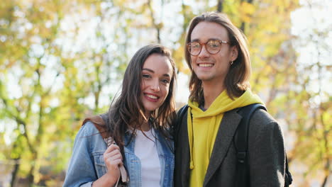 young caucasian woman and caucasian man wearing glasses looking aside