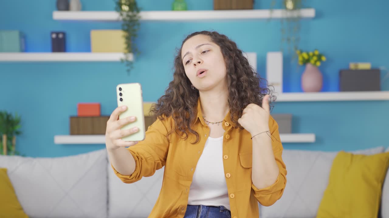 mujer joven haciendo una videollamada por teléfono.