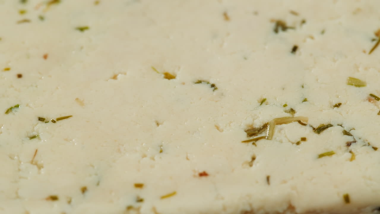 Fried tofu with sesame seeds and spices on cast iron pan, cooking japanese salad. Healthy ingredient for cooking vegan vegetarian diet food. Roasted tofu over black background.