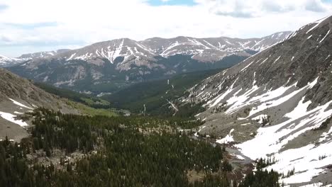 cinematic flight revealing an inspiring horizon through a ravine in the mountains
