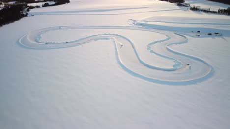 whole race track on a frozen lake in finland during golden hour – aerial winter landscape high altitude