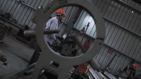 slow-motion-India-metallurgy-factory-workers-wearing-helmet-works-in-production-manufacturing-line-during-night-shift