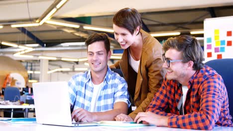 Executives-discussing-over-laptop