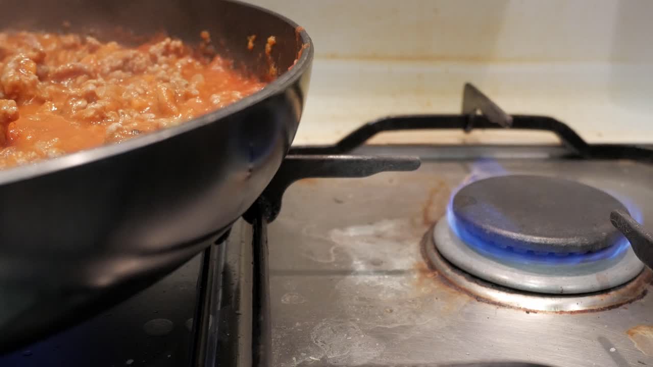 Bolognese-sovs simrer på komfuret, varm madlavningsstemning
