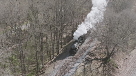 slow motion aerial drone shot of a steam train engine moving down the tracks in chattanooga, tn