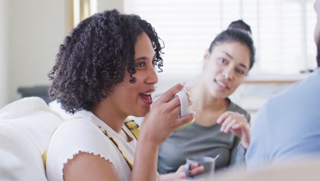 Diverse-male-and-female-friends-talking-and-having-tea-at-home-in-slow-motion