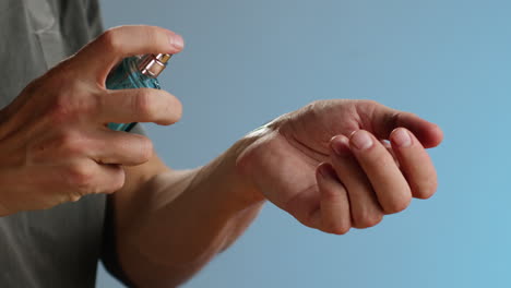young man applying perfume to skin in the dark, close up of spraying deodorant luxury perfume.