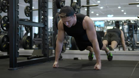 Handsome-young-man-in-gym-doing-push-ups-on-the-floor-in-slow-motion