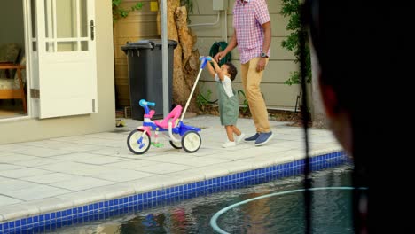 side view of young black father and little son playing in back yard of their home 4k