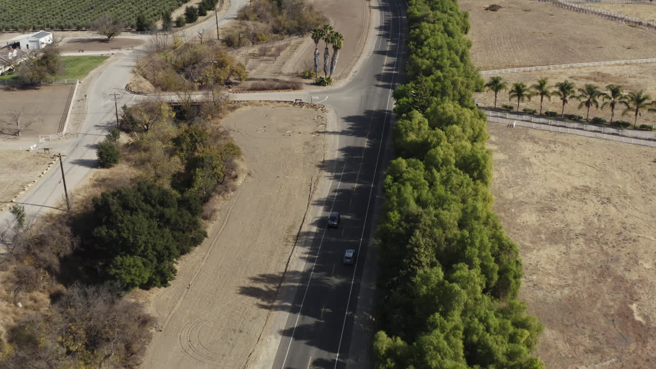 toma aérea de un todoterreno policial encubierto conduciendo por una carretera rural