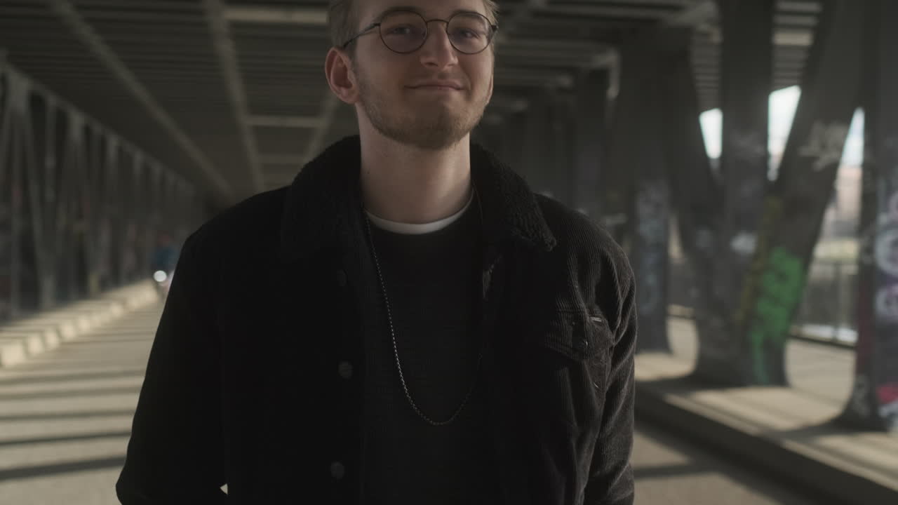 молодой европейский мужчина идет и улыбается, когда мимо него проезжают велосипеды на пустой дороге в гамбурге, германия