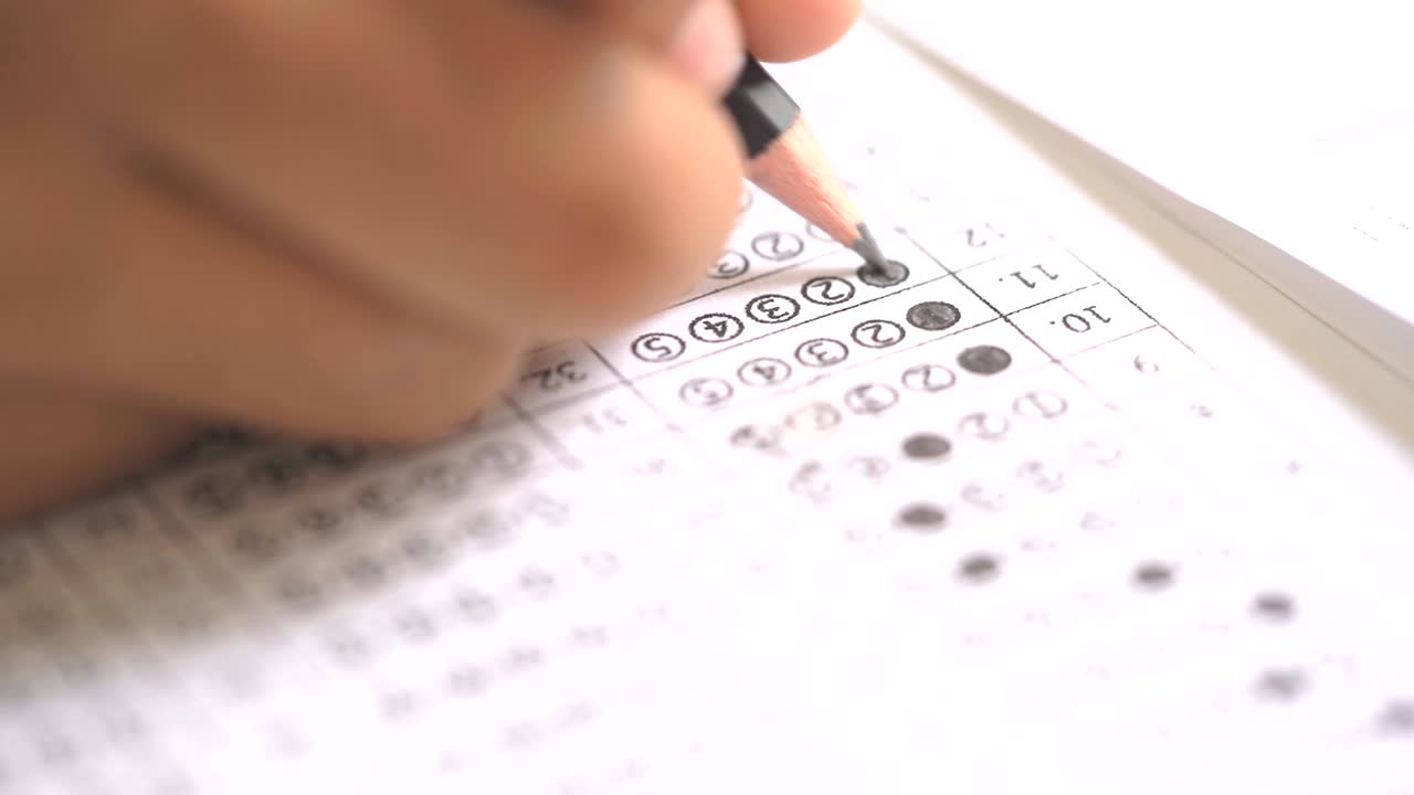 Test exam concept, pencil writing answer on paper answer of question in examination test.