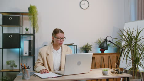 Businesswoman-freelancer-enters-office-workplace,-working-on-laptop-computer,-sends-online-messages