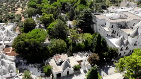 a dji drone take a sstatic panoramic of alberobello above the main historical road full of trulli