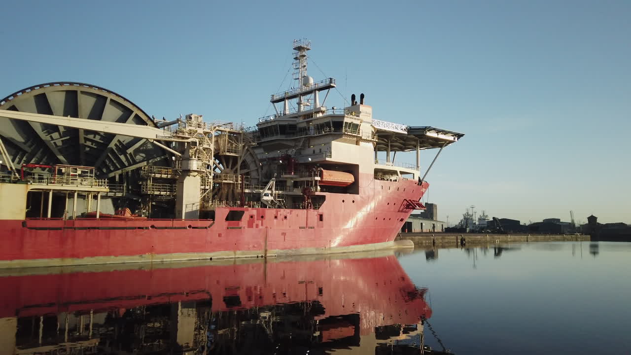 pan a través de un cable rojo tendido barco atracado en albert dock basinon un tranquilo y soleado día de invierno, edimburgo, lothian, reino unido