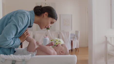 happy mother gently kissing baby enjoying loving mom playfully caring for toddler on changing table at home sharing connection with her newborn child healthy childcare