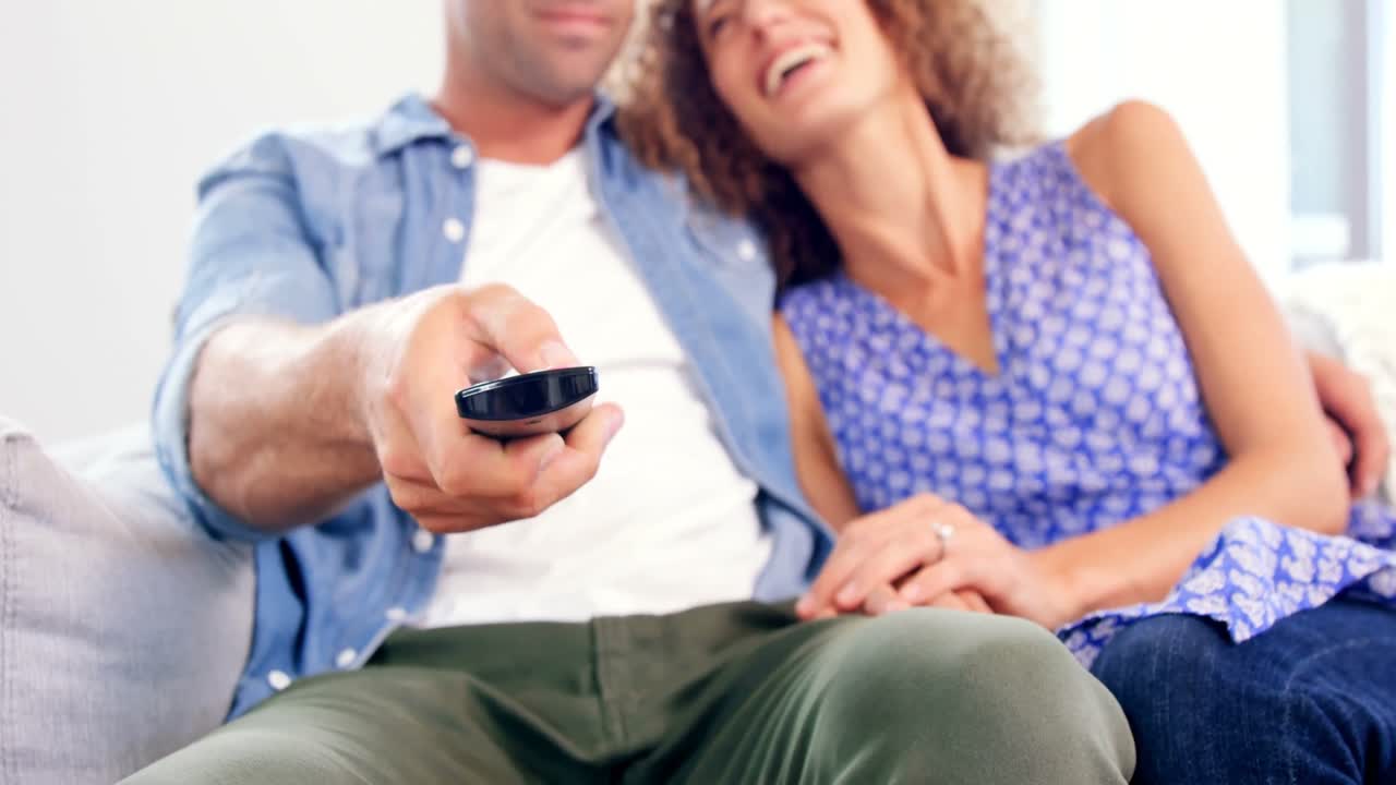 젊은 커플이 tv를 보고 있다