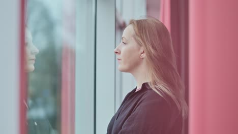 slow motion closeup, blonde woman facing street with serious look and reflection