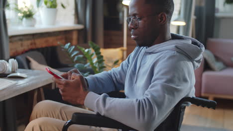 man in wheelchair using smartphone